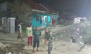 Babinsa dan Warga Bersih-Bersih Irigasi di Malam Hari